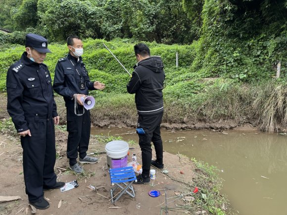 执法人员向钓鱼爱好者宣传文明钓鱼相关政策.