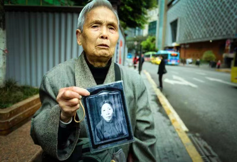 簡全碧老人拿著她祖母的送別世相片。重慶大轟炸民間對日索賠原告團 供圖