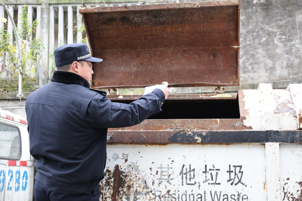 張華爬上垃圾運收車進行檢查。華龍網記者 王慶煉  攝