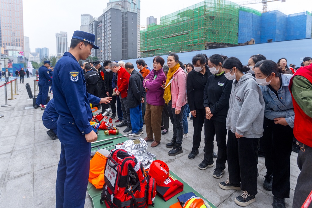 消防员向市民介绍各类消防器材的使用方法和操作流程。主办方供图 华龙网发