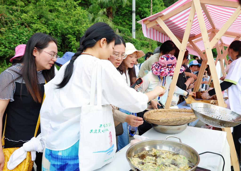 游客品尝特色美食“茶叶粑”。华龙网 简梦 摄