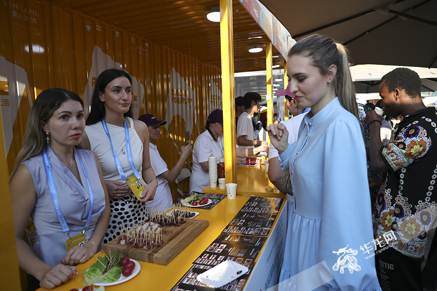 外国友人们在美食街品尝美食。华龙网首席记者 李文科 摄