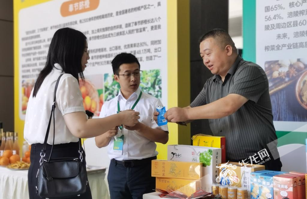 活动现场，一名工作人员向参会人员介绍涪陵榨菜。华龙网 陈雨 摄