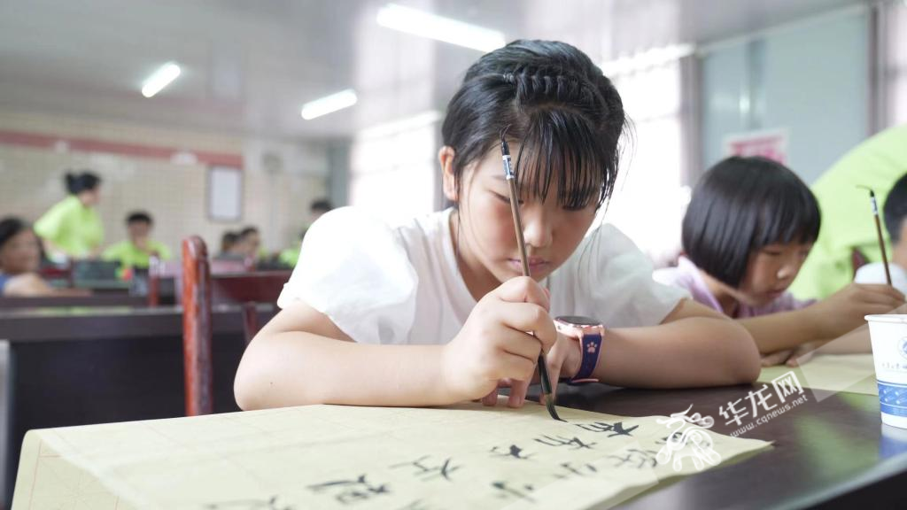 小朋友在大学生指导下写毛笔字。 华龙网记者 刘钊 摄