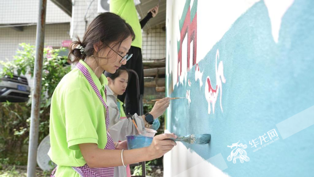 大学生在房屋墙面彩绘。  华龙网记者 刘钊 摄