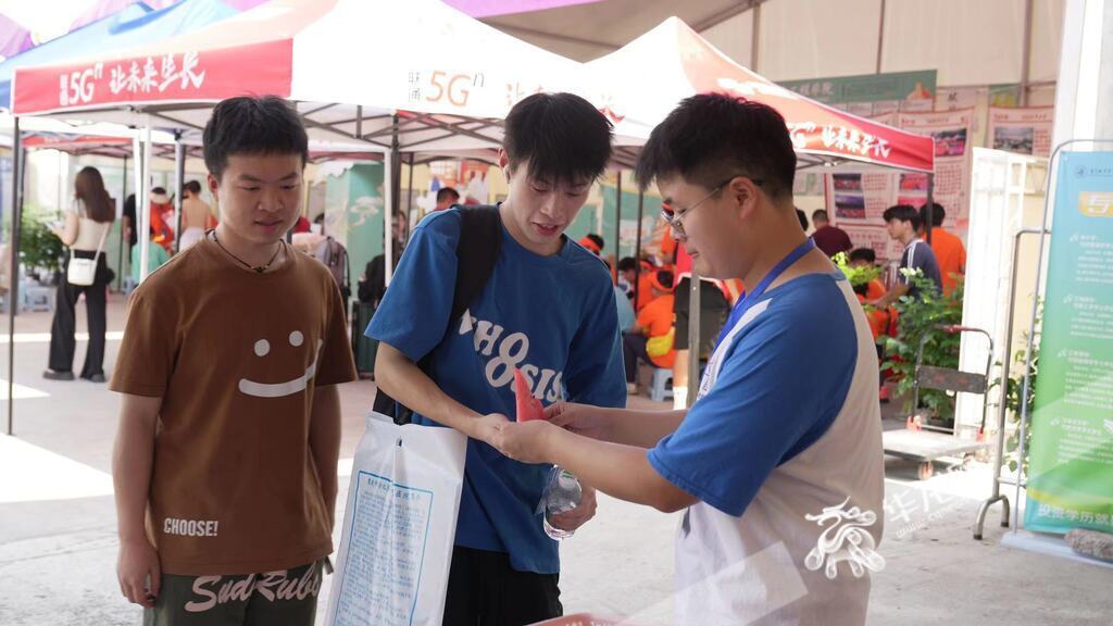 工作人员为新生递上西瓜解暑。 华龙网记者 刘钊 摄
