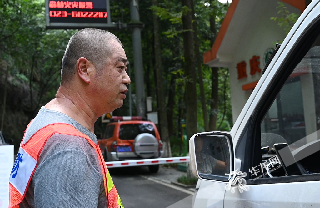 黛湖保护站护林员李建仔细询问进出车辆的人员信息。(华龙网记者 刘润 实习生 林靖昂 摄)