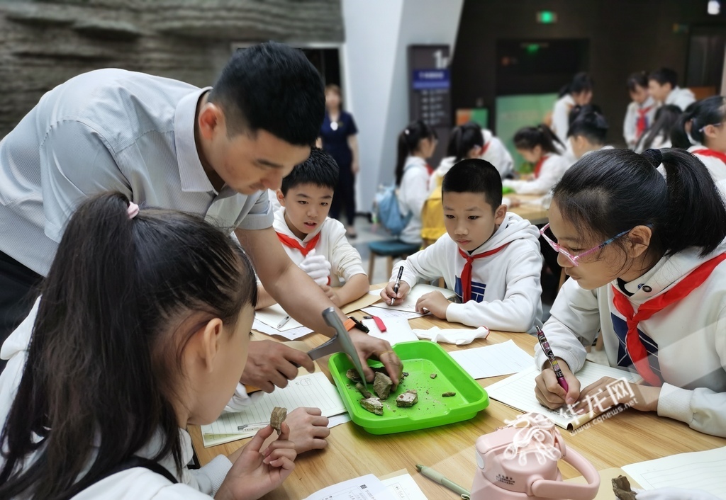 活动现场，同学们学习使用地质锤。华龙网 陈雨 摄