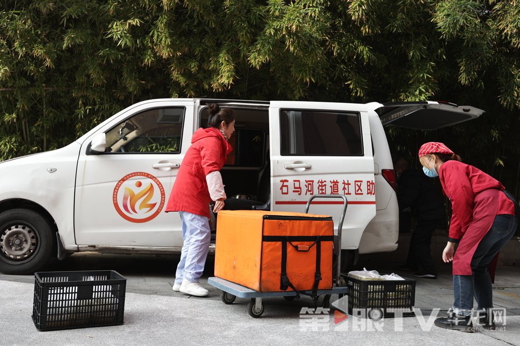 工作人员正在分装饭菜，准备配送。第1眼TV-华龙网记者 陈洋 罗盛杰 摄