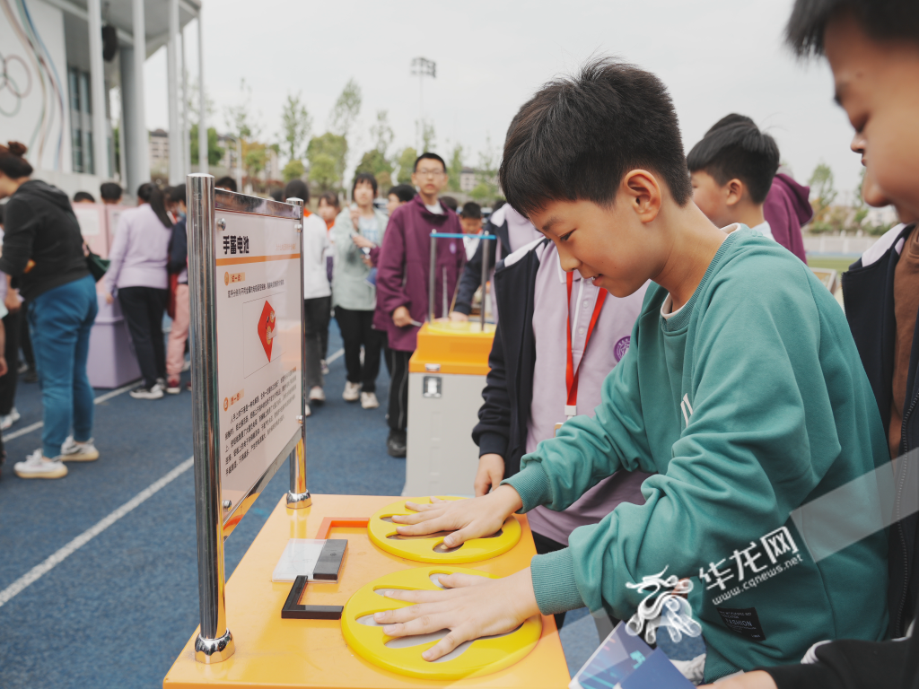 手蓄电池吸引学生现场体验。 华龙网记者 刘钊 摄