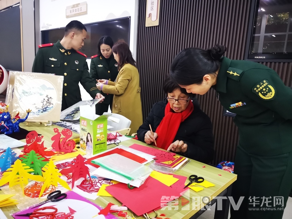 武警戰士在向民間藝術家學習剪紙。第1眼TV-華龍網記者 伊永軍 攝