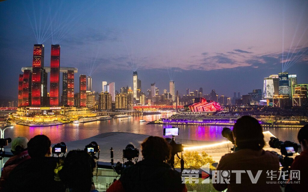 除夕之夜,华灯初上,一抹晚霞映照在山城夜空,众多市民拿着手机、相机拍照录像,记录美好时刻。