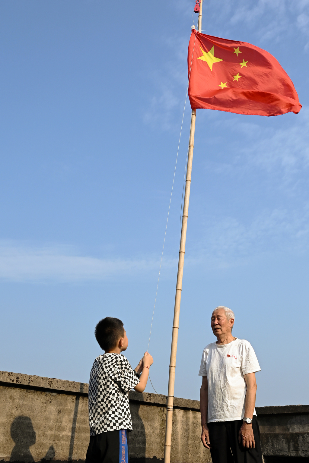 張廷福和曾外孫一起升旗。