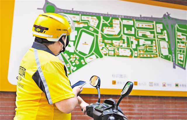 A fast food deliver watching the plan available at the entrance of Xinticun Community, Yubei Road Sub-district, Shapingba District (Photographed by Zhang Zhi / Visual Chongqing)