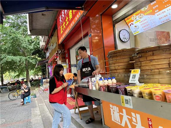 重庆高新区虎溪街道社区网格员向辖区商户宣传世界粮食日。花马社区供图