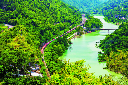 西部陸海新通道綦江區(qū)扶歡鎮(zhèn)東升壩路段，一列色彩明快的列車(chē)疾馳而過(guò)。特約通訊員 胡光銀 攝