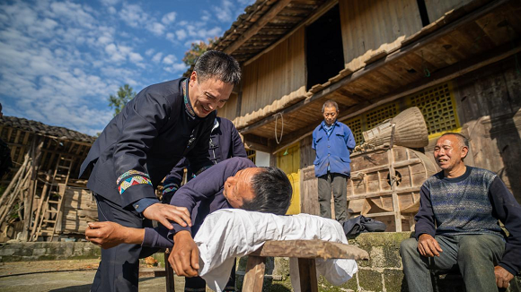 非遗传承人为群众做健康服务。冉林 摄