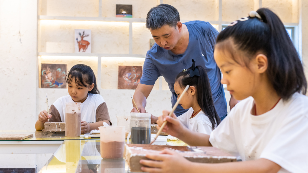 走教教师王宽在指导双龙乡小学学生制作泥板画