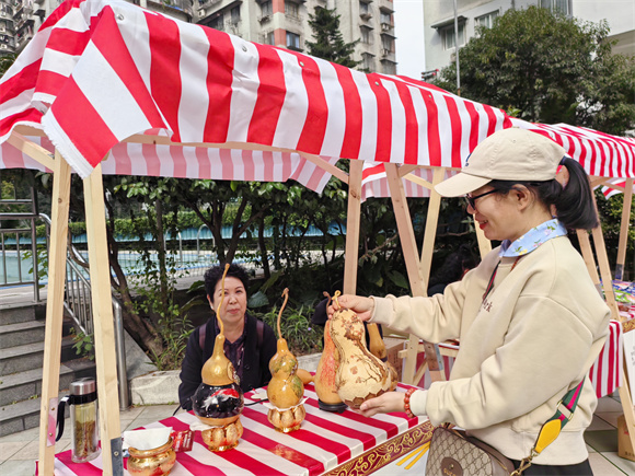 居民欣赏非遗葫芦烙画作品。龙溪街道办事处供图  华龙网发