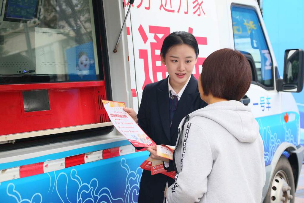 （图1）图为重庆农商行渝北支行员工向活动现场的群众介绍社保卡“五免”政策