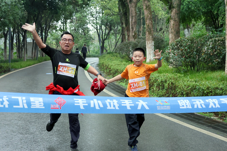 家長帶著孩子沖向終點。大竹林街道供圖 華龍網(wǎng)發(fā)