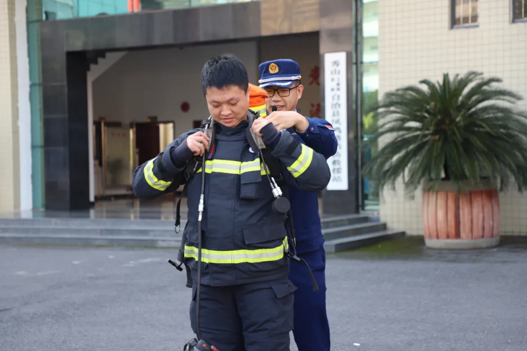 消防宣传员指导参训人员进行防护服穿着体验。秀山县消防救援局供图 第1眼TV-华龙网发