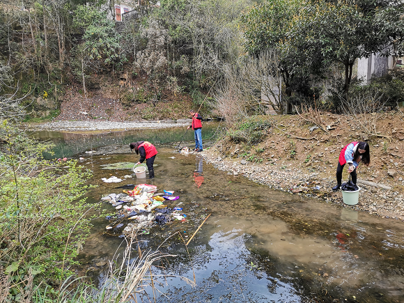 工作人员清理河道漂浮物。通讯员 杨乐 摄