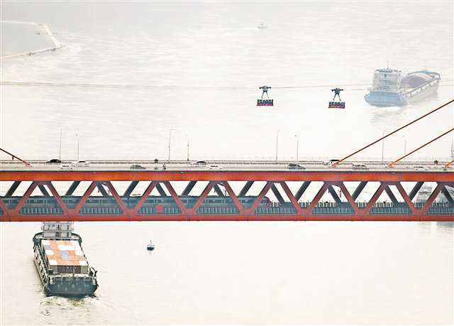 The train, the cableways, the boats, and the running vehicles on the Dongshuimen Yangtze River Bridge in Chongqing formed a three-dimensional traffic picture on April 15.