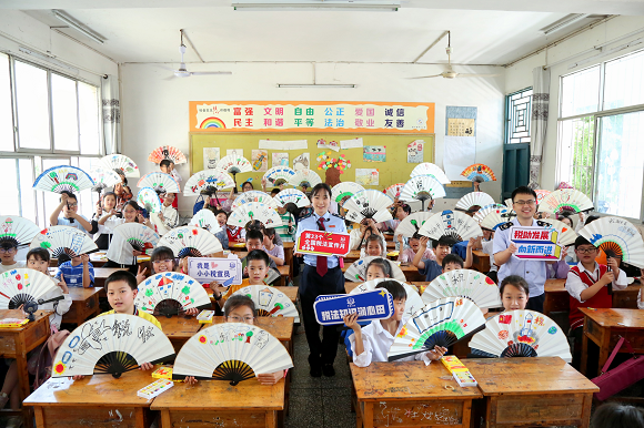 在开州区临江镇中心小学，同学们展示自己亲手做的税法主题手工折扇。赵诗琦 摄