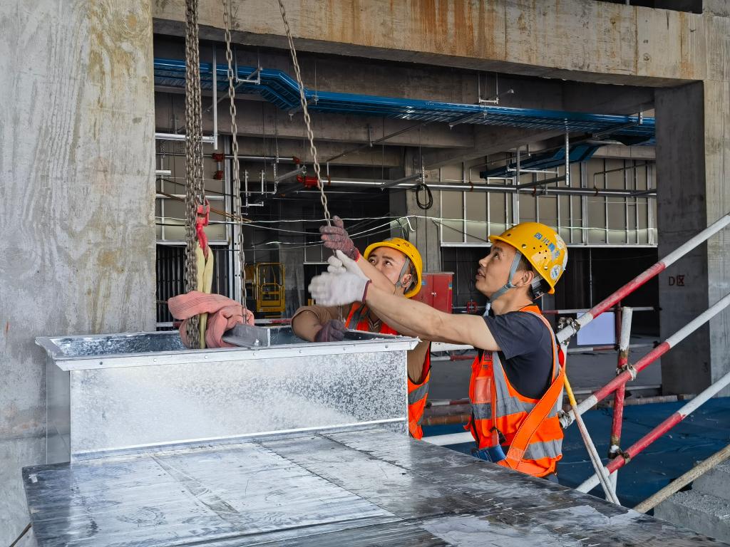 工人进行机电风管安装作业。中建八局供图