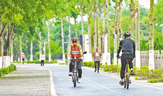 On May 8, citizens are cycling and strolling on the tree-lined Lijia Shancheng Footpath in Liangjiang New Area.