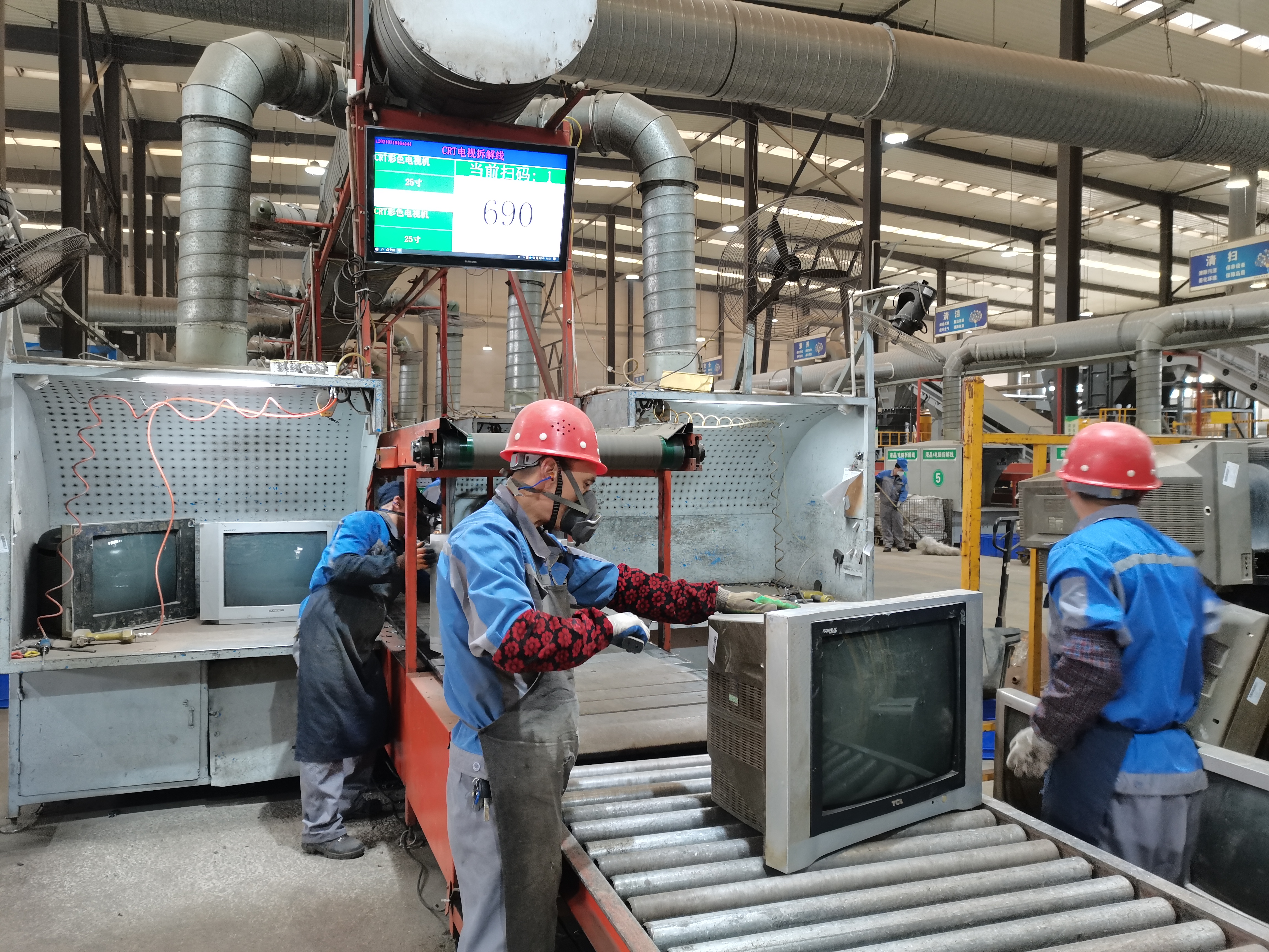 重庆中天电子废弃物处理有限公司厂区内，工作人员正在拆解废旧电视机。受访单位供图