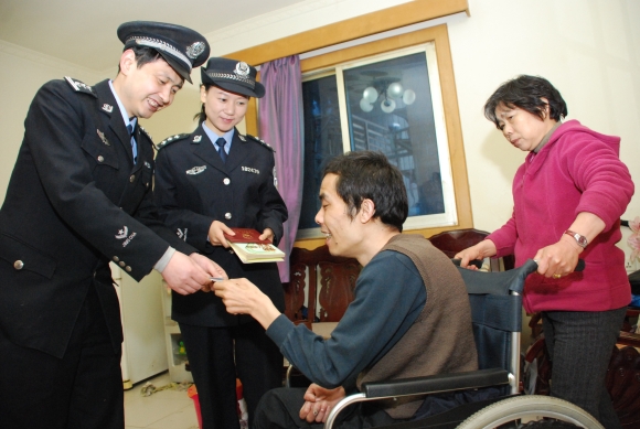 2006年，江北区公安分局观音桥商业区派出所渝北社区民警江涌为辖区居民送上办理好的户口簿和身份证。江北区委宣传部供图 华龙网发