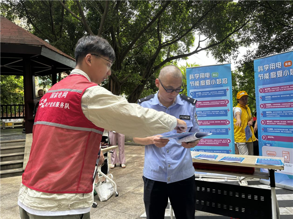 国网重庆物资公司员工为大竹林派出所的民警介绍科学节能用电知识。通讯员 徐铮 摄