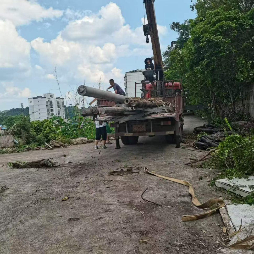 潼南区调派工程车搬运堆放的废旧电杆。重庆市生态环境局供图