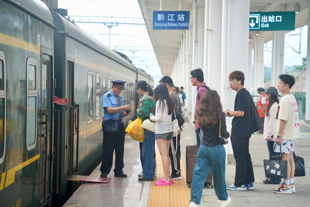 旅客在黔江新站乘坐K202次列车前往重庆。通讯员 黄松 摄