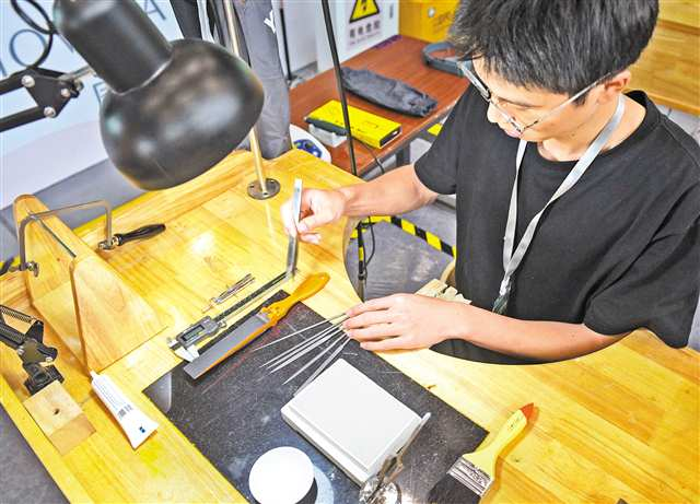 The staff preparing tools for the contestants on the operation table for jewelry processing item. (Photographed by Zhang Jinhui / Visual Chongqing)