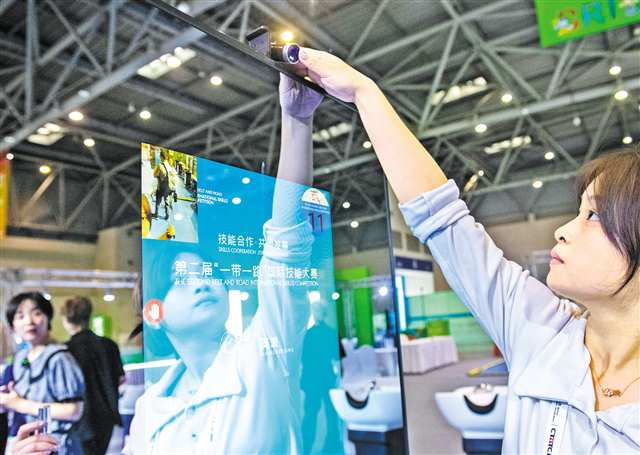 The staff debugging the camera on the smart mirror stand used in the hair salon item. (Photographed by Zhang Jinhui / Visual Chongqing)