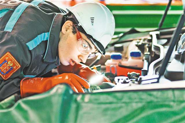 A competitor was carrying out troubleshooting of a new energy vehicle on June 25. (Photographed by Li Yuheng / Visual Chongqing)