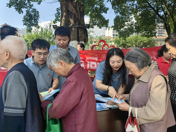 工作人员向市民发放宣传资料。苏梅汝 摄