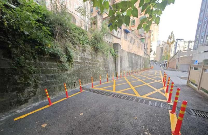涪陵区荔枝街道稻香苑幼儿园附近巷道新安装的隔离桩及新施划的禁停黄线。重庆市生态环境局供图