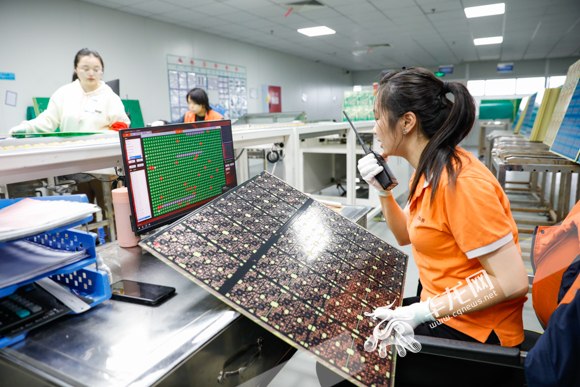 工人正在使用产品检验光学设备对印制电路板进行检测。（资料图）