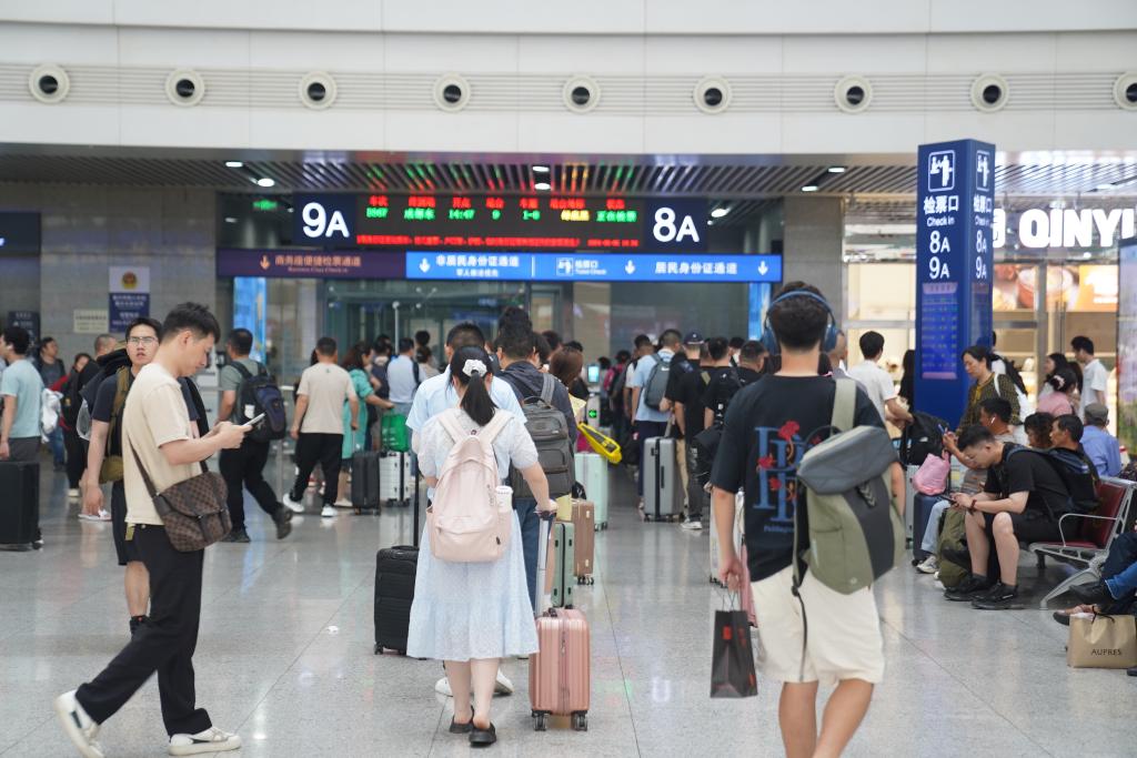 6月6日，旅客在检票口前有序排队乘车。通讯员 魏伟 摄