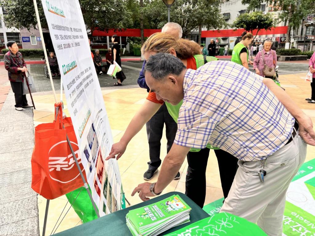 工作人员结合展板和宣传资料，向居民普及垃圾分类知识和垃圾分类重要性。康美街道供图 华龙网发