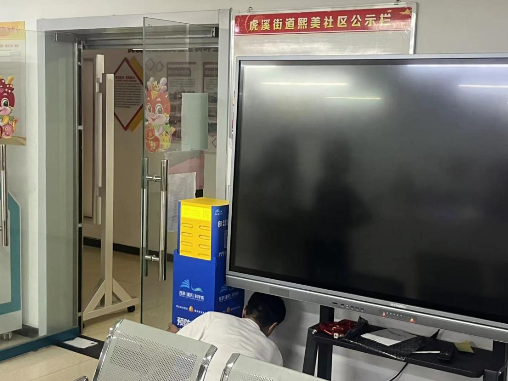 工作人员正在共享充电宝柜机上张贴安全宣传贴纸。重庆高新区应急管理局供图 华龙网发