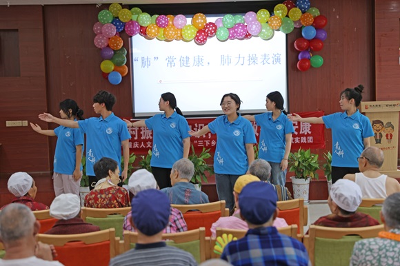 实践团学生为老人们开展肺力操表演。通讯员 赵勇 摄