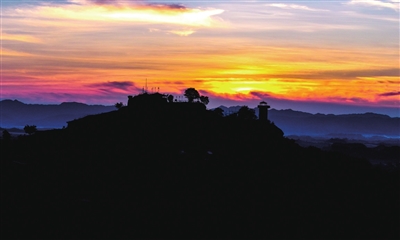 滑石古寨景区，晚霞绯红，群山、古寨与霞光勾勒出一幅绝美剪影画。记者 熊伟 摄