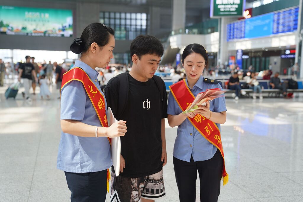 文明引导员发放《铁路旅客文明出行倡议》宣传单。铁路部门供图