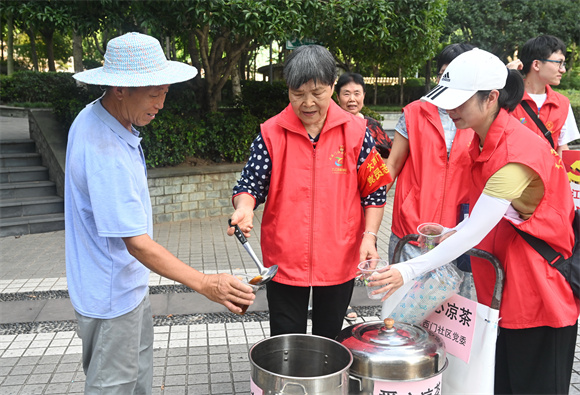 户外工作者领取解暑凉茶。张渝 摄