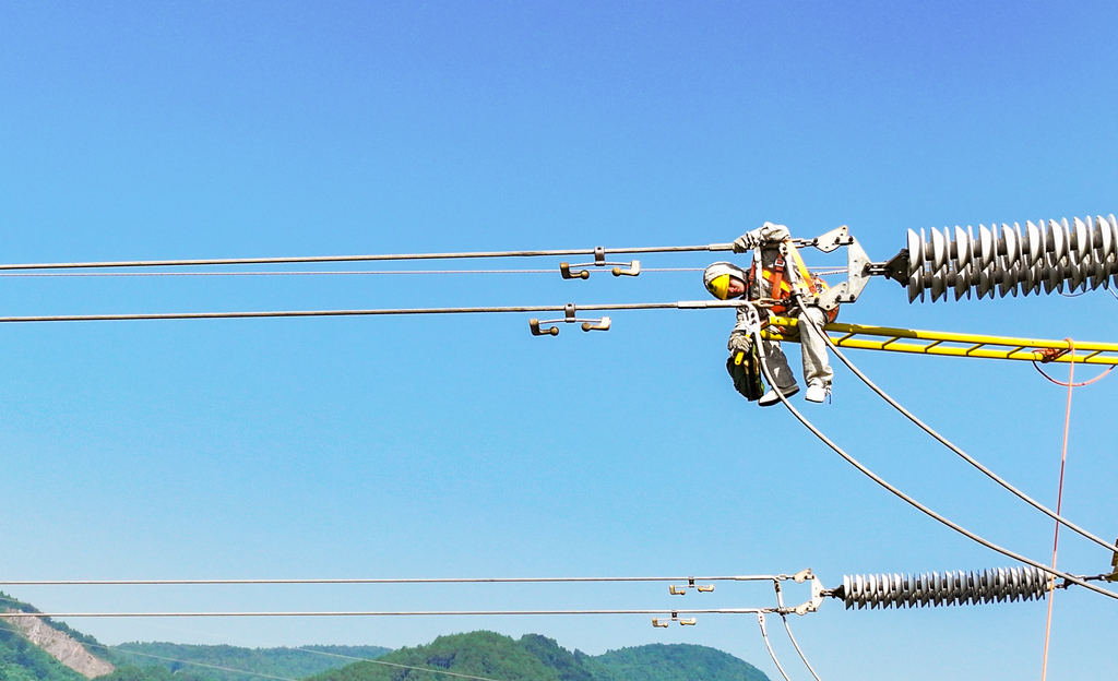 電力工作人員對220千伏長莊東線24號鐵塔帶電處理高溫發(fā)熱隱患。通訊員 況敏 攝